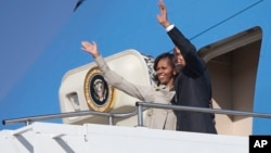 U.S. President Barack Obama and first lady Michelle Obama wave as they depart Waterkloof Air Base for a flight to Cape Town, June 30, 2013, in Centurion, South Africa. 