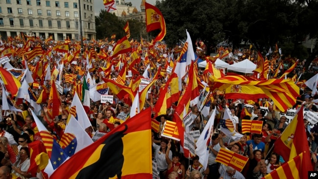 Ciudadanos agitan banderas de Cataluña y España mientras celebran un día de fiesta conocido como el "Día de la Hispanidad" en Barcelona, España, 12 de octubre de 2017.