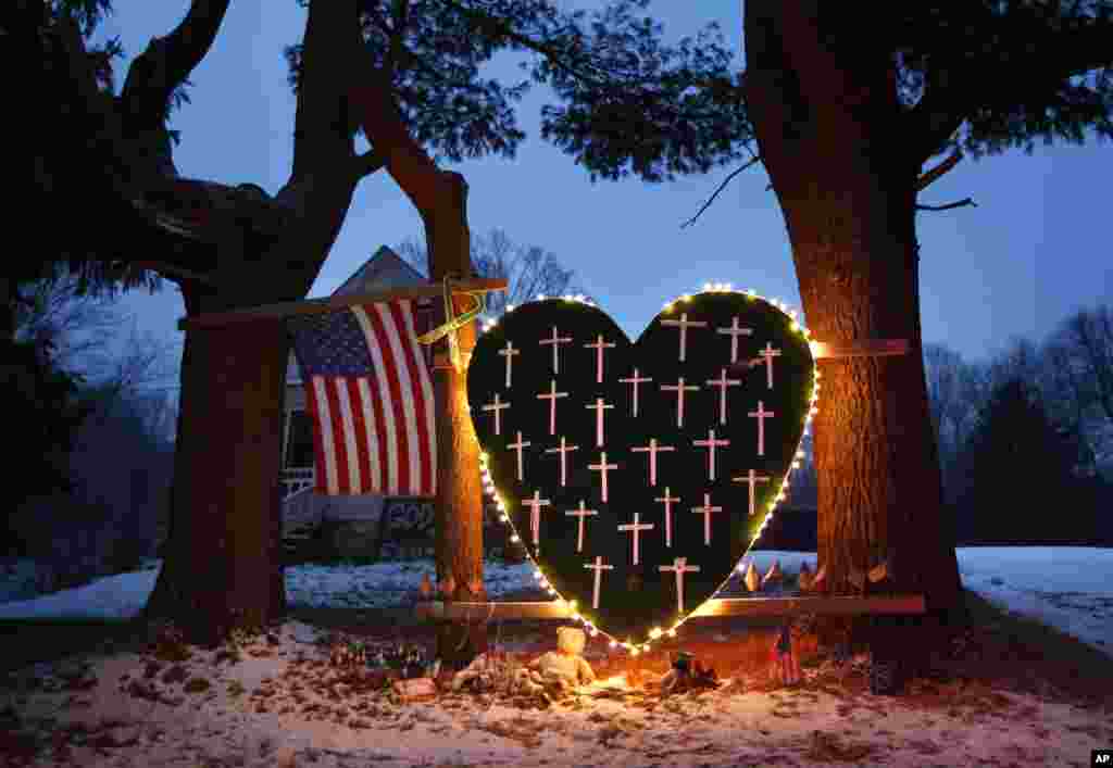 A makeshift memorial with crosses for the victims of the Sandy Hook massacre stands outside a home in Newtown, Conn., Dec. 14, 2013.
