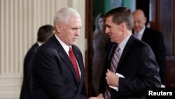 FILE - Vice President Mike Pence greets then-National Security Adviser Michael Flynn at the White House in Washington, Feb. 10, 2017.