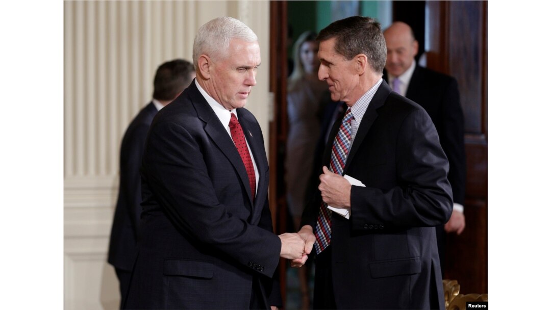 FILE - Vice President Mike Pence greets then-National Security Advisor Michael Flynn at the White House in Washington, Feb. 10, 2017.