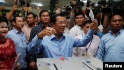 Cambodian Prime Minister Hun Sen prepares to cast his vote as his wife, Bun Rany, stands beside him at a polling station during a general election in Takhmao, Kandal province, Cambodia, July 29, 2018.