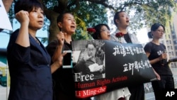 Supporters of Taiwanese activist Lee Ming-che detained in China, chant their support during a media event in Taipei, Taiwan, Nov. 28, 2017.