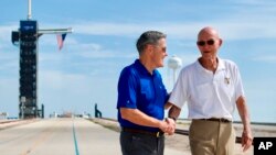 In this Tuesday, July 16, 2019 photo made available by NASA, astronaut Michael Collins, right, speaks to Kennedy Space Center Director Bob Cabana at Launch Complex 39A, about the moments leading up to launch at 9:32 a.m. on July 16, 1969, and what it was 