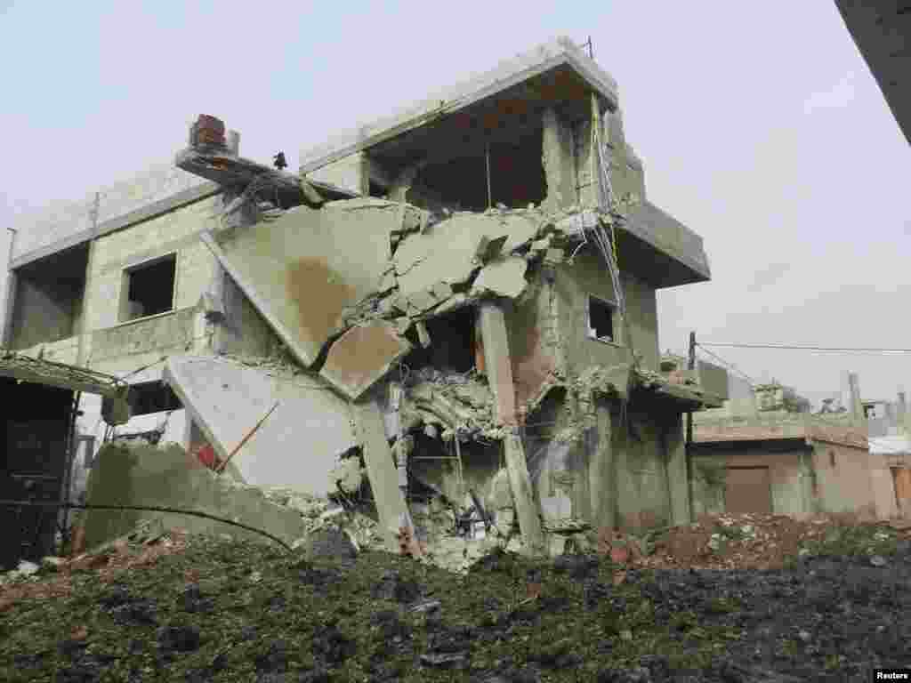 Buildings damaged after a Syrian Air Force fighter jet fired missiles at Houla, near Homs, December 3, 2012.