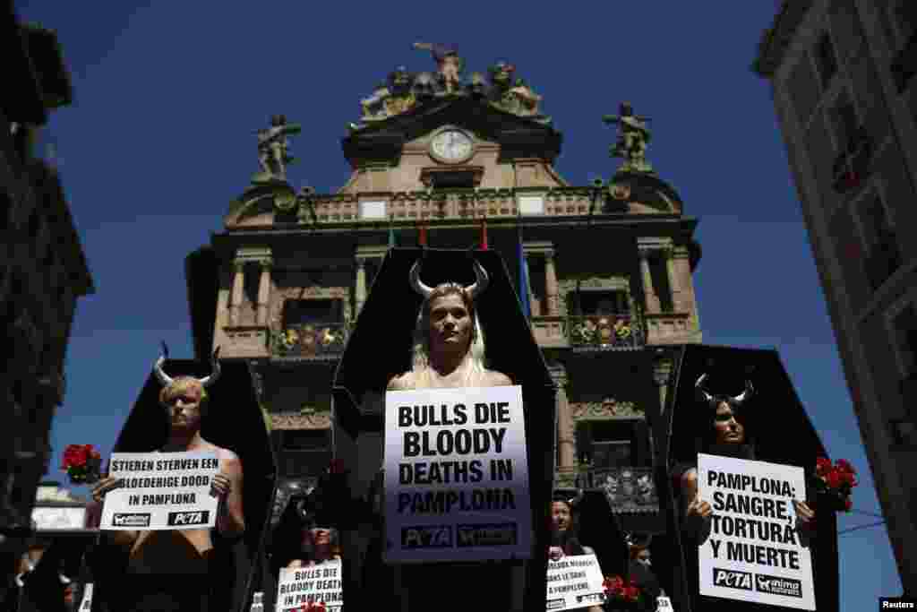 Những người biểu tình bênh vực cho quyền của súc vật đứng bên trong một một quan tài bằng carton trong một cuộc biểu tình đòi bãi bỏ sinh hoạt bò chạy và đấu bò, một ngày trước khi mắt đầu mùa bò chạy tại lễ hội San Fermin, ờ Pamplona, Tây Ban Nha.