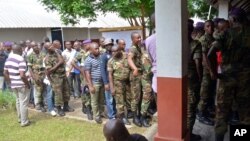 Des soldats et des civils congolais font la queue pour voter devant un bureau de vote, à Brazzaville, République du Congo, 20 mars 2016.