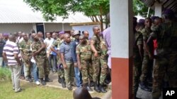 Des soldats et des civils congolais font la queue pour voter devant un bureau de vote, à Brazzaville, République du Congo, 20 mars 2016.