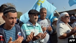 FILE - Crimean Tatars pray as they block the road at the checkpoint between Ukraine and Crimea, in Chongar, September 20, 2015. Hundreds of representatives of the Muslim Crimean Tatar community took part in a blockade from Ukraine to the Crimean peninsula annexed by Russia in March 2014, to protest against the violation of their rights. 