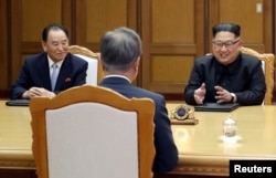 North Korean leader Kim Jong Un talks with South Korean President Moon Jae-in as Kim Yong Chol, North Korea's Vice-chairman of the central committee of the Workers' Party of Korea (WPK), listens during their summit at the truce village of Panmunjom, North Korea.