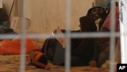 Foto yang diambil dari video pada tanggal 9 September ini menunjukkan seorang perempuan dan anak kecil tidur di lantai tenda di kamp pengungsi di pinggiran Mosul, Irak.