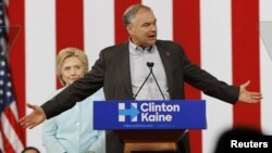 Hillary Clinton mendengar Cawapres Tim Kaine memberikan pidato kepada kerumunan pendukungnya yang sangat antusias di Miami, Florida hari Sabtu (23/7).