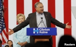 Democratic U.S. presidential candidate Hillary Clinton listens to her choice for running mate, Senator Tim Kaine of Virginia, after she introduced him during a campaign rally in Miami, Florida, July 23, 2016.