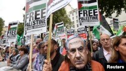 A demonstrator wears a Benjamin Netanyahu mask with a message written on it during a protest outside Downing Street in London, Britain Sept. 9, 2015. 