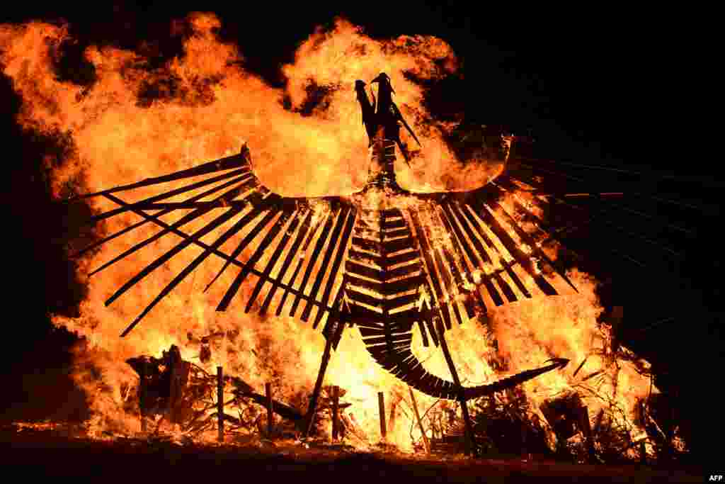 A bonfire featuring a large wooden phoenix burns at the Glastonbury Festival of Music and Performing Arts on Worthy Farm near the village of Pilton in Somerset, South West England.