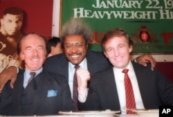 FILE - Donald Trump, right, pictured with his father, Fred Trump, far left, and boxing promoter Don King at a news conference in Atlantic City, N.J., in December 1987.