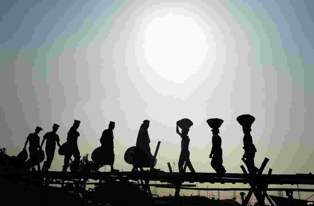 Bangladeshi laborers unload sand from cargo ship in Dhaka.