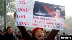 An anti-China protester holds up a poster bearing an image of South Vietnamese naval captain Nguy Van Tha, who was killed during a naval clash with China at the Paracels islands.