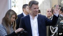 El presidente de Colombia, Juan Manuel Santos, saluda a los reporteros antes de emitir su voto en Bogotá, Colombia.