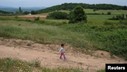 A child who tried to cross the border walks back to a makeshift camp for refugees and migrants at the Greek-Macedonian border near the village of Idomeni, Greece, May 11, 2016.