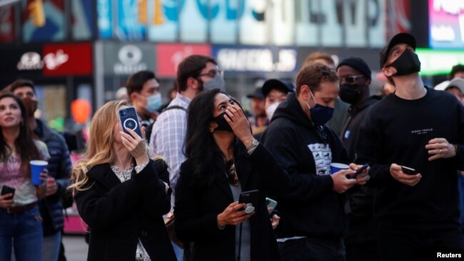 Employees of Coinbase Global Inc, the biggest U.S. cryptocurrency exchange, watch as their listing is displayed on the Nasdaq MarketSite jumbotron at Times Square in New York, U.S., April 14, 2021. REUTERS/Shannon Stapleton