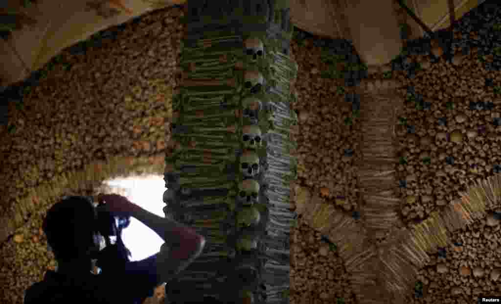 A tourist takes pictures at the Bones chapel in Evora, Portugal, April 5, 2017.