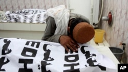 A Pakistani mourns over a dead body of his family member who is killed in a bomb attack, at a mortuary in Quetta, Pakistan, July 13, 2018.