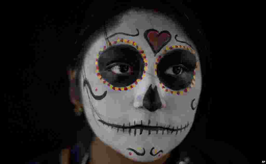 Seorang anak perempuan dengan wajah dilukis&nbsp;sebagai&nbsp;&quot;Catrina&quot; menunggu dimulainya&nbsp;acara Zombie Walk di La Paz, Bolivia, 28 Oktober 2017.