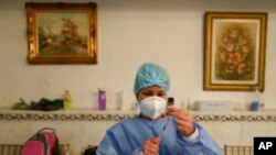 Una doctora prepara una dosis de la vacuna contra el COVID-19 de Sinopharm, durante una campaña de vacunación en una escuela en Caracas, el 3 de septiembre de 2021.