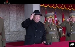 In this image made from video by North Korea's KRT, North Korean leader Kim Jong Un, center, attends a military parade in Pyongyang, North Korea Thursday, Feb. 8, 2018.