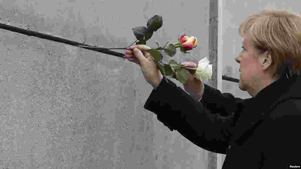La chancelière allemande Angela Merkel pose une rose au mémorial du mur de Berlin&nbsp;à Bernauer Strasse, pendant une cérémonie marquant le 25ème anniversaire de la chute du mur de Berlin, Berlin, Allemagne. 