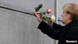 Kanselir Jerman Angela Merkel meletakkan bunga di monumen peringatan Tembok Berlin di Bernauer Strasse, Berlin (foto: ilustrasi).