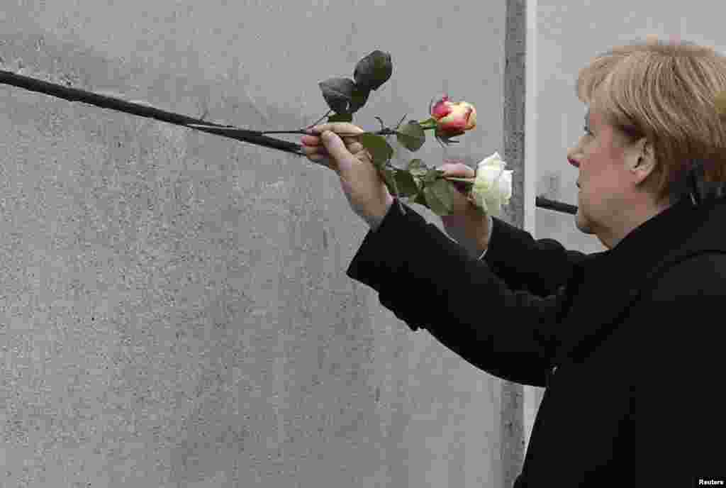 German Chancellor Angela Merkel places a rose at the Berlin Wall memorial in Bernauer Strasse, during a ceremony marking the 25th anniversary of the fall of the Berlin Wall, Berlin, Germany. 