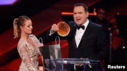 FILE - Host Norm Macdonald removes a pancake from a spoof "swag bag" at the 2016 Canadian Screen Awards in Toronto, Ontario, March 13, 2016.