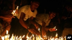 Protesters hold candles during a candlelight vigil at Sule Pagoda in Rangoon, Burma, May 23, 2012. 