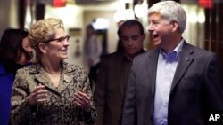 FILE - Michigan Gov. Rick Snyder and Ontario Premier Kathleen Wynne walk to a news conference, March 13, 2017, in Detroit. Snyder and Wynne stressed that they want their voices heard as President Donald Trump demands a negotiation of trade policies betwee