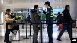 Hành khách được kiểm tra thân nhiệt tại Sân bay quốc tế Thiên Hà Vũ Hán, thuộc tỉnh Hồ Bắc, miền nam Trung Quốc, ngày 21/1/2020.