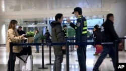 中國湖北省武漢市天河國際機場工作人員測試旅客的體溫。（2020年1月21日）