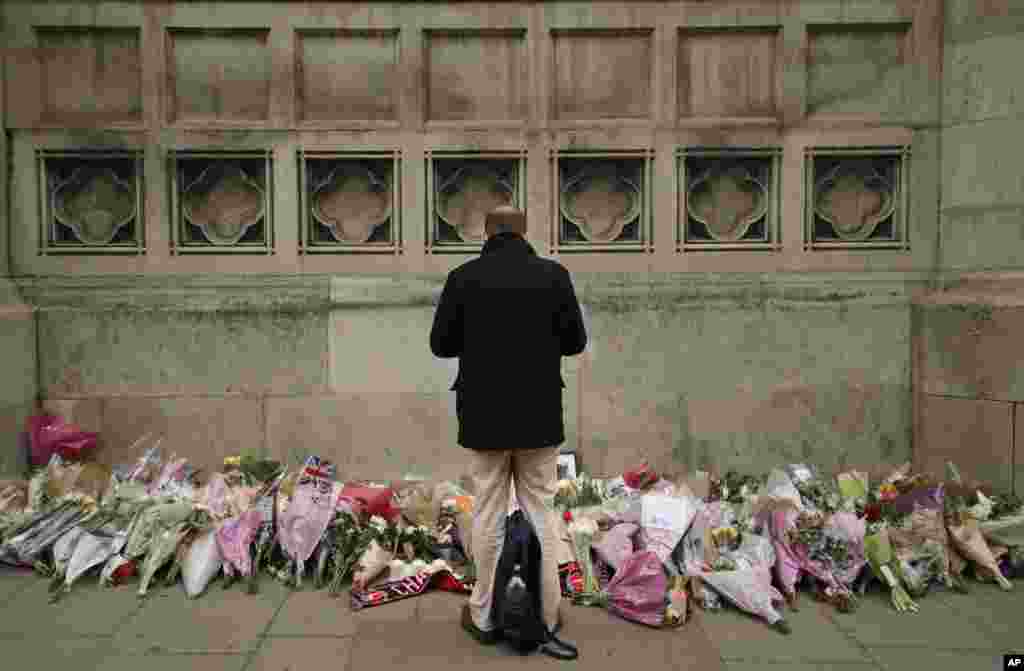 یکی از ساکنان لندن یاد قربانبان حمله اخیر این شهر را در مقابل پارلمان گرامی می دارد.