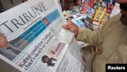A man reads a newspaper containing news about Afghan Taliban leader Mullah Akhtar Mansour at a stall in Peshawar, Pakistan, May 23, 2016. 