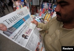 A man reads a newspaper containing news about Afghan Taliban leader Mullah Akhtar Mansour at a stall in Peshawar, Pakistan, May 23, 2016.