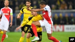 Kylian Mbappé de Monaco, à droite, tire le maillot de son co-équipier Lukasz Piszczek lors du match de quart de finales de la Ligue des champions entre l’AS Monaco et Borussia Dortmund à Dortmund, Allemagne, 22 avril 2017.