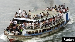 FILE - An overcrowded ferry plies the Buriganga river in Dhaka, Bangladesh, May 2002.