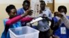 Uma delegada eleitoral mostra um boletim de voto durante a contagem no fim das eleições gerais em Luanda, Angola. 13 de Agosto 2017