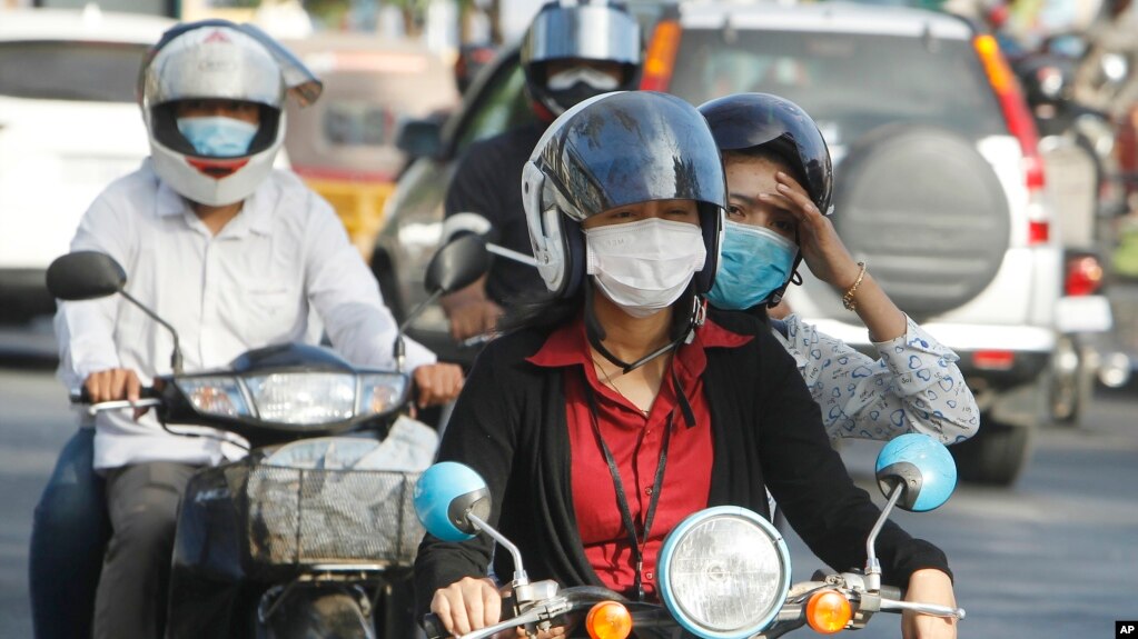 Cambodians wear masks to avoid the contact of coronavirus in Phnom Penh, Cambodia, Tuesday, Jan. 28, 2020. (AP Photo/Heng Sinith