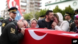 Family members mourn over the coffin of Ugur Palanci, 28, during a funeral ceremony in Izmir, Turkey, March 2, 2018. Taha Palanci was one of eight Turkish soldiers killed Thursday in fighting against Syrian Kurdish militia in Afrin, northwestern Syria.