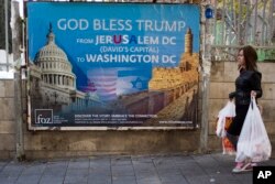 A woman walks past a poster praising U.S. President Donald Trump’s recognition of Jerusalem as Israel’s capital, in Jerusalem, Dec. 7, 2017.