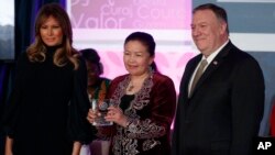 Sayragul Sauytbay, of China nominated by Kazakhstan, receives her award from first lady Melania Trump and Secretary of State Mike Pompeo during the 2020 International Women of Courage Awards Ceremony at the State Department in Washington Feb. 4, 2020. (AP Photo/Carolyn Kaster)