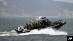 FILE - South Korean navy sailors in a speed boat patrol around South Korea's western Yeonpyong Island after finishing their exercise, near the disputed sea border with North Korea, February 20, 2012.