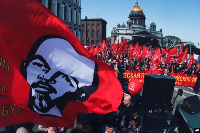 Communist party supporters carry a flag depicting Soviet Union founder Lenin during a May Day rally in St. Petersburg, Russia, May 1, 2019.
